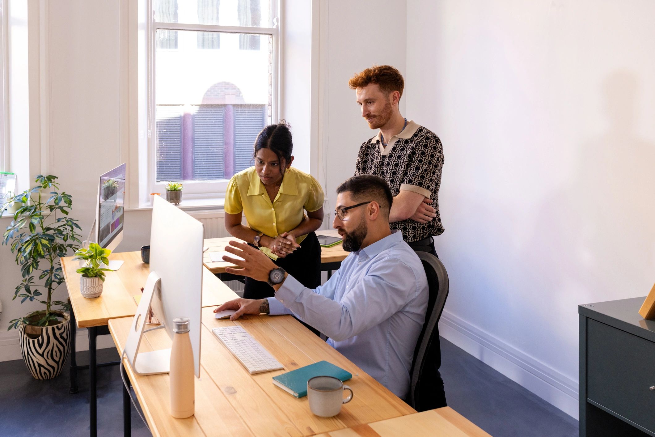 Finance and technology team reviewing work together in a modern office