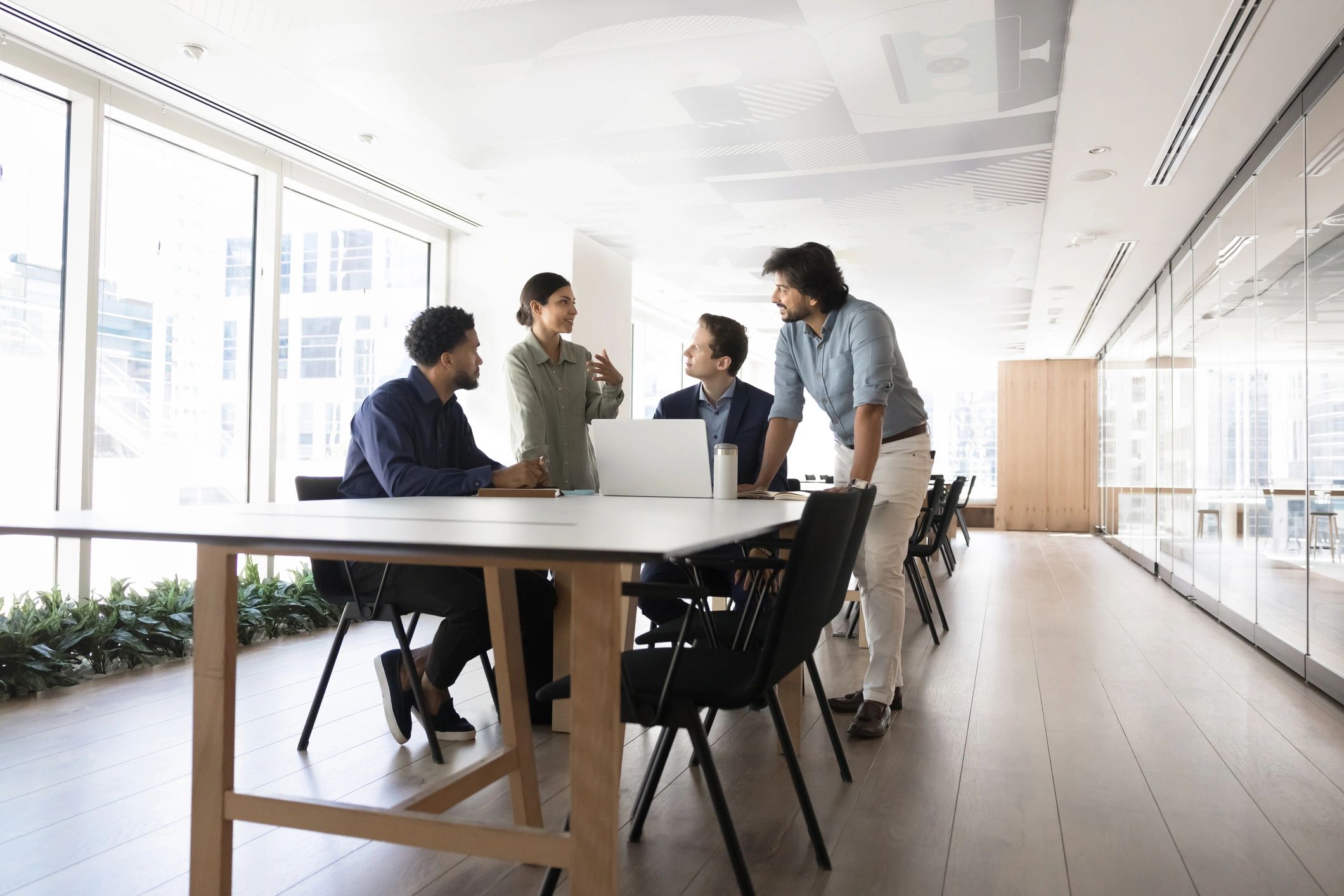 Business consultants collaborating around a table with a laptop